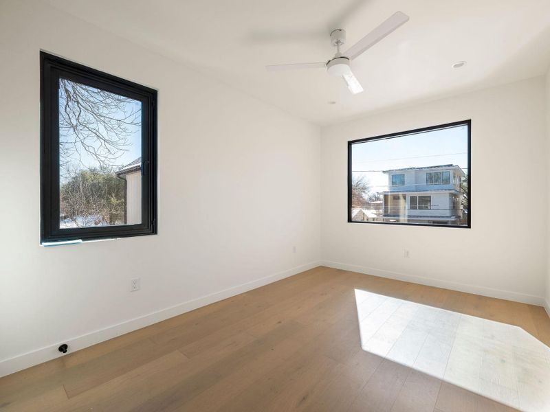 Empty room featuring hardwood / wood-style flooring and a ceiling fan