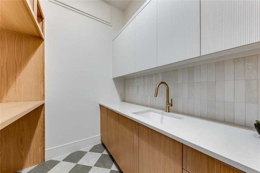 Bar with sink, white cabinets, and decorative backsplash