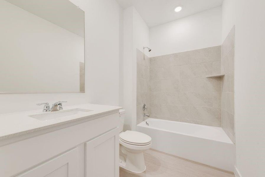 Full bathroom with shower / bath combination, vanity, and light wood-style flooring Full bathroom with shower / bath combination, vanity, and light wood-style flooring