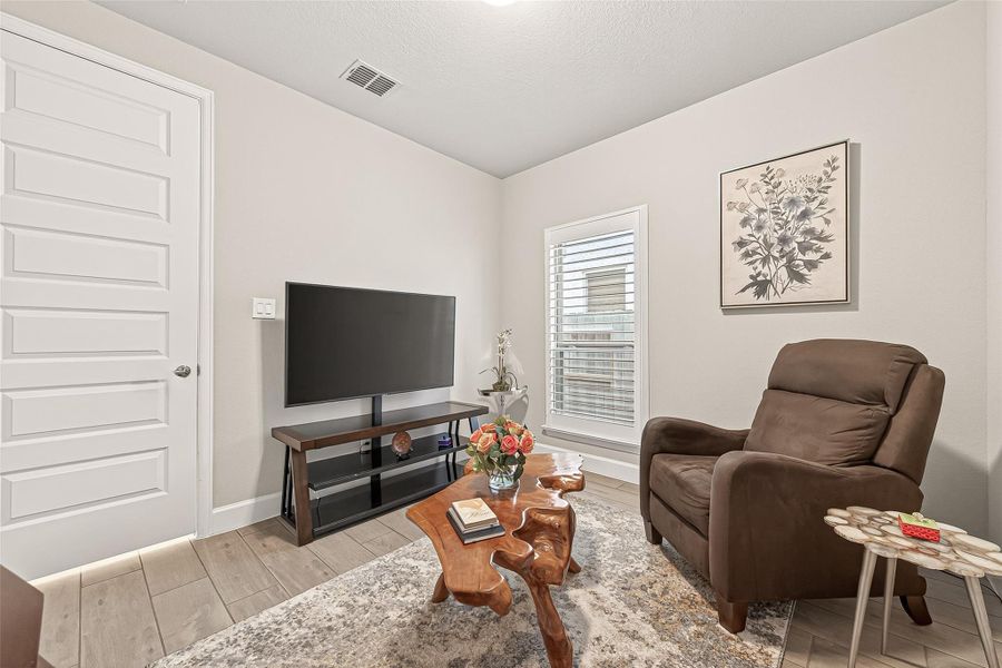 Versatile secondary bedroom space with room for a dedicated seating or lounge area. (Note: Photo is staged; property is currently vacant.) Versatile secondary bedroom space with room for a dedicated seating or lounge area. (Note: Photo is staged; property is currently vacant.)