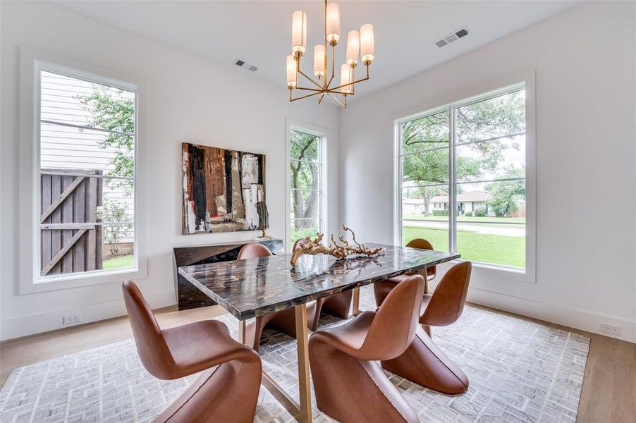 Dining space featuring light hardwood / wood-style flooring, plenty of natural light, and a chandelier