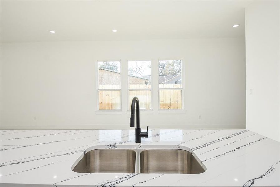 This stunning kitchen island features a sleek quartz waterfall countertop, a deep stainless steel double sink, and a modern black faucet. Perfect for meal prep, entertaining, and everyday living!