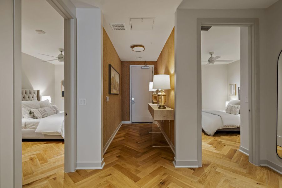 Herringbone hardwood floors extend from the welcoming entry into adjacent well-lit sleeping quarters.