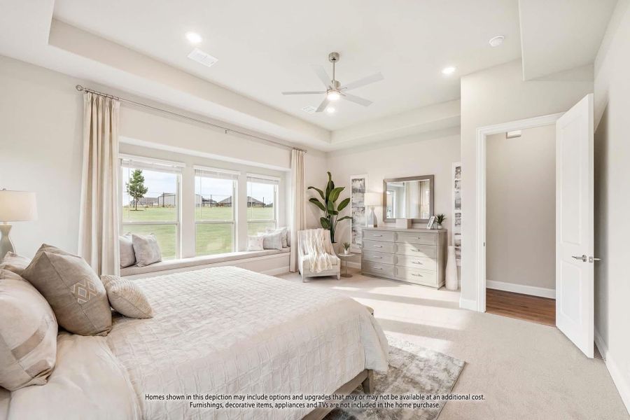 Master bedroom with tray ceiling, ceiling fan, window seat, and neutral carpet flooring Master bedroom with tray ceiling, ceiling fan, window seat, and neutral carpet flooring