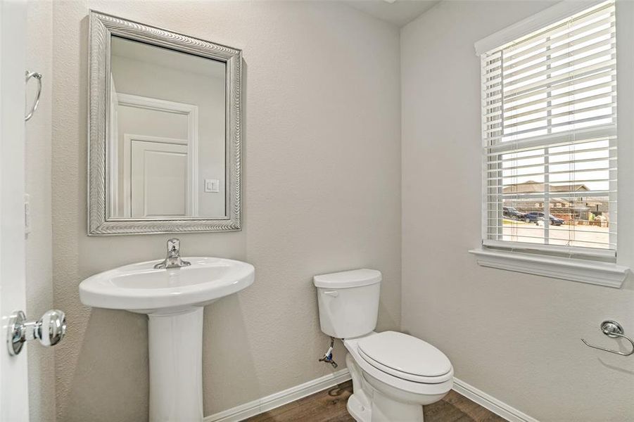 Guest 1/2 bath near entrance. Pedestal sink with chrome faucet and framed mirror Guest 1/2 bath near entrance. Pedestal sink with chrome faucet and framed mirror
