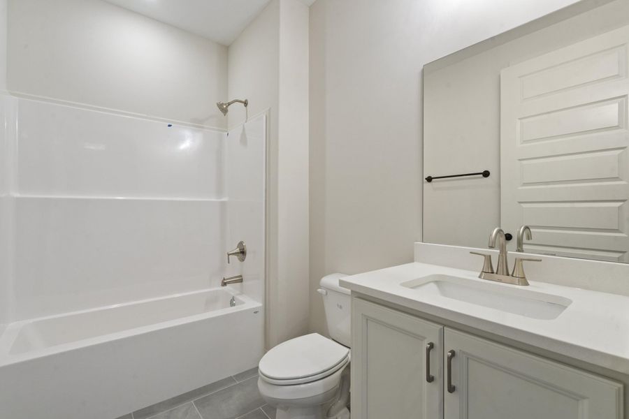 White vanity with brushed nickel hardware, integrated sink, and white countertop White vanity with brushed nickel hardware, integrated sink, and white countertop