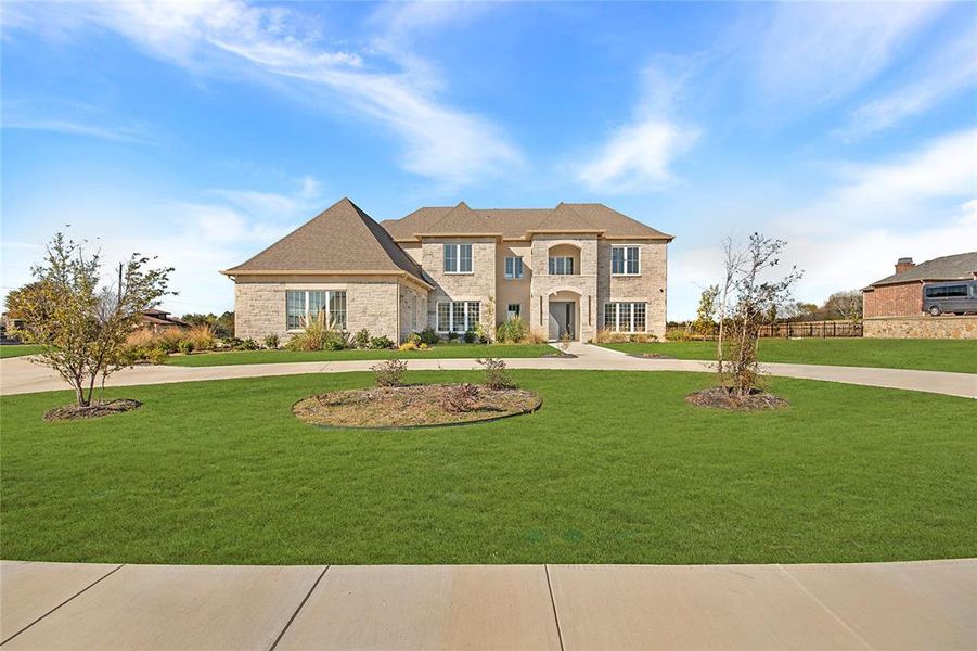 French provincial home featuring curved driveway, a front yard, and brick siding French provincial home featuring curved driveway, a front yard, and brick siding