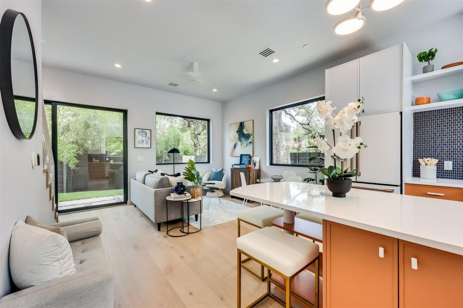 The whole main floor feel like one giant, open-air hangout, with large windows and an easy transition from the kitchen to the living