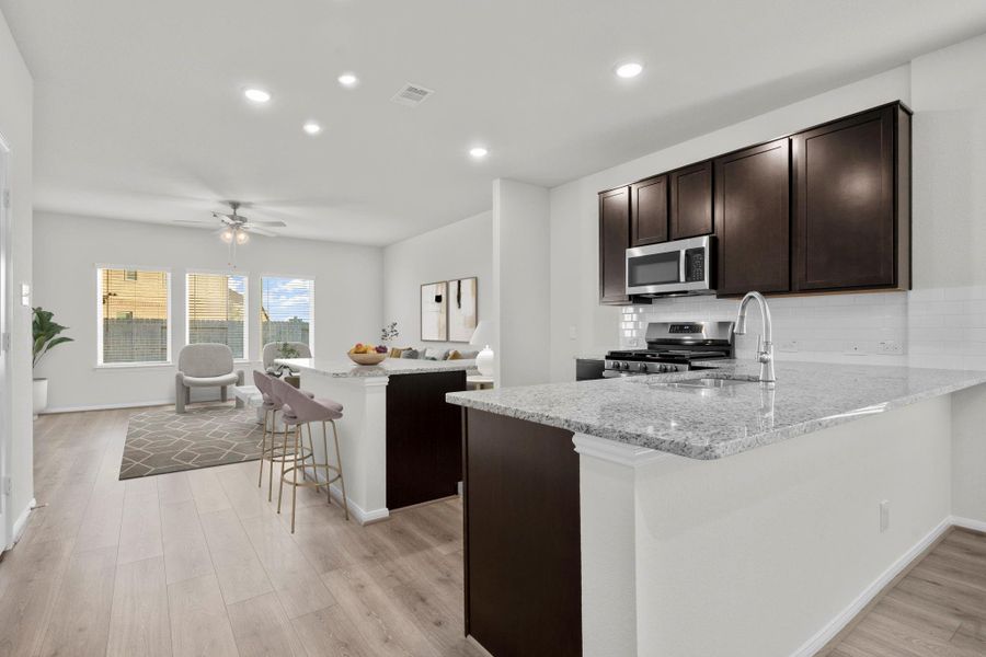 The open-concept kitchen flows effortlessly into the family and dining areas, creating a bright and airy layout perfect for entertaining. Enjoy the combination of dark cabinetry, granite countertops, and sleek stainless-steel appliances that give this space a polished, modern feel. The open-concept kitchen flows effortlessly into the family and dining areas, creating a bright and airy layout perfect for entertaining. Enjoy the combination of dark cabinetry, granite countertops, and sleek stainless-steel appliances that give this space a polished, modern feel.