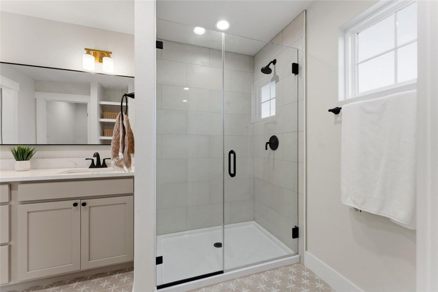 Organic, modern tile flooring pairs beautifully with oat-colored cabinetry and marble-look stone countertops. Generous storage and an oversized walk-in closet add everyday functionality.