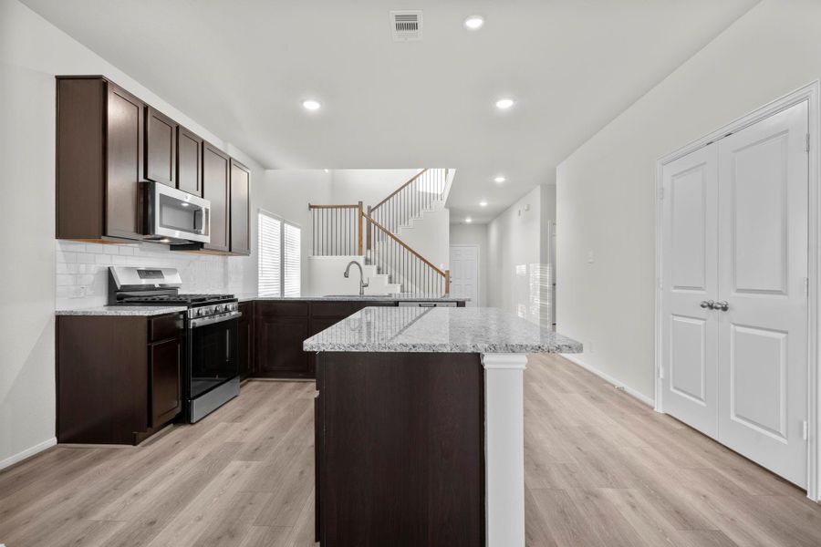 A closer look at the gourmet kitchen reveals beautiful shaker-style cabinetry, sparkling granite surfaces, and a gas range ready for your favorite recipes. The open layout makes cooking and socializing easy, with views extending to the family room. To your right French doors open to large walk in pantry, A closer look at the gourmet kitchen reveals beautiful shaker-style cabinetry, sparkling granite surfaces, and a gas range ready for your favorite recipes. The open layout makes cooking and socializing easy, with views extending to the family room. To your right French doors open to large walk in pantry,