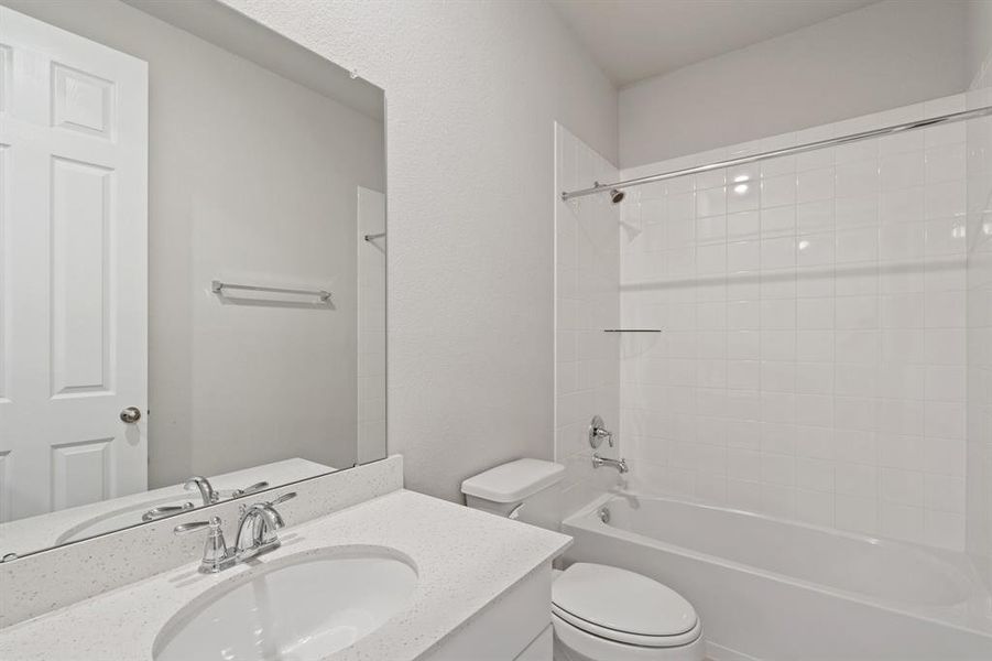 The secondary bath features tile flooring, white cabinetry and light countertops and a shower/tub combo. Perfect for accommodating any visiting family and friends.