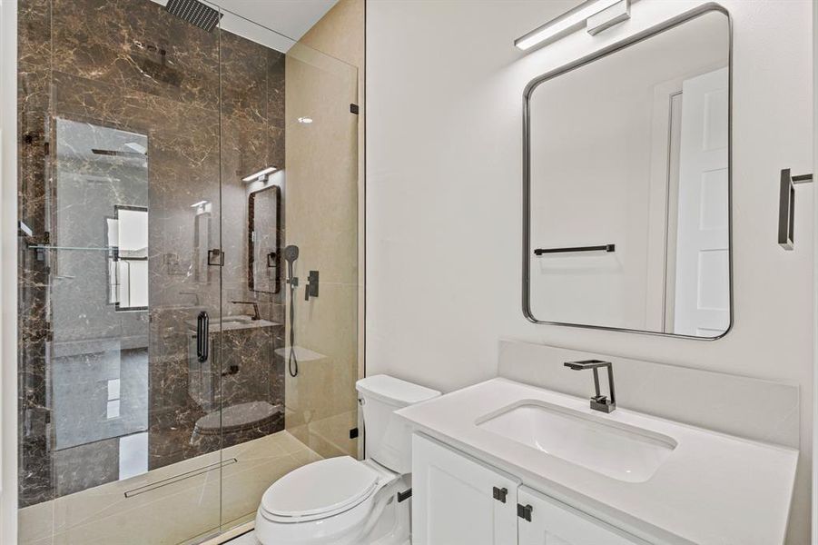 Full bath featuring toilet, a stall shower, and vanity