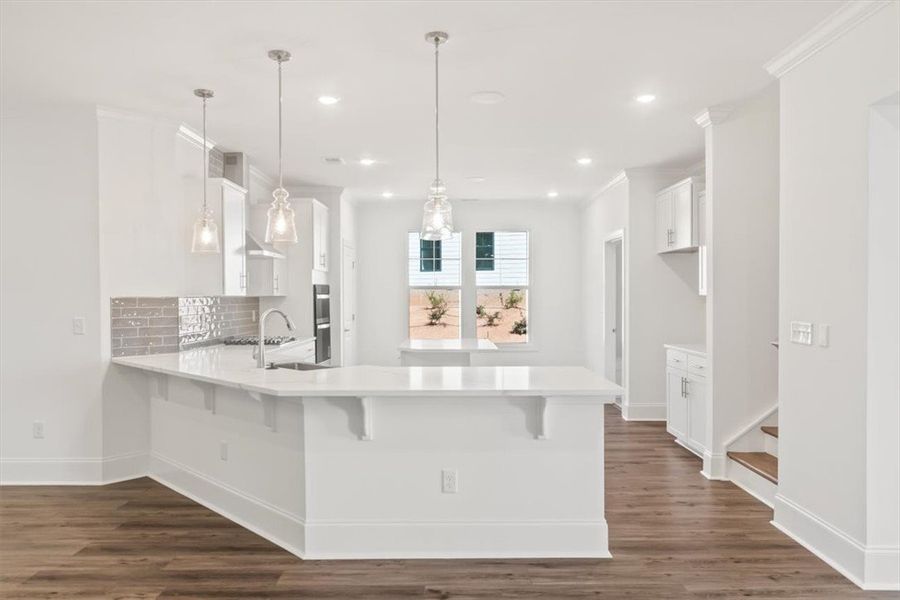 An open kitchen boasts gleaming quartz counters, r