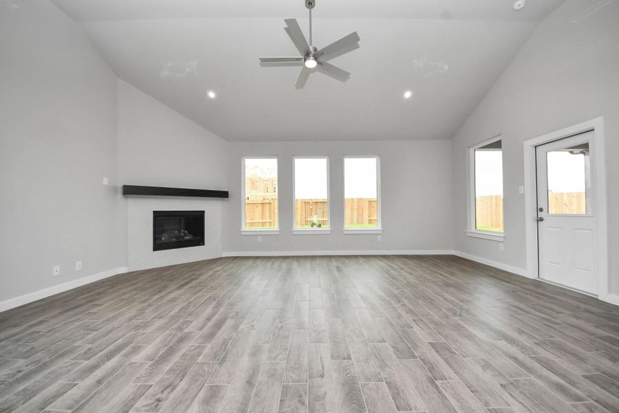 Bring the family and guests together in the welcoming family room! Enjoy the expansive space adorned with high ceilings, recessed lighting, a stylish ceiling fan, custom paint, exquisite flooring, and generously sized windows that fill the room with an abundance of natural light, creating a warm and inviting atmosphere for everyone to enjoy! Sample photo of completed home with similar floor plan. Actual colors and selections may vary.