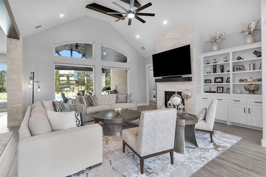 The main areas of the home have woodgrain tile. In the main living area or heart of the home, note the stone touches, stone to ceiling fireplace, built-ins, esspresso-color beams and beautiful view to the back.