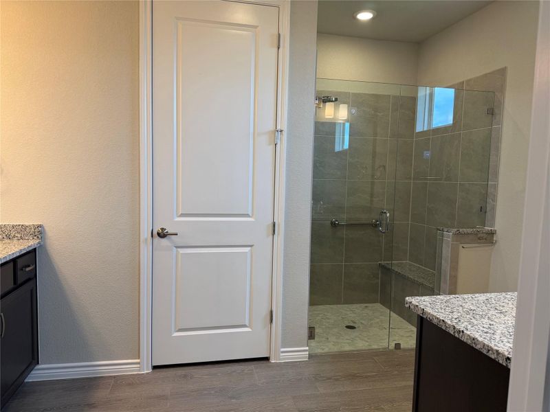 Elegant shower enclosure with tiled walls and a built-in bench, offering a serene bathing experience.