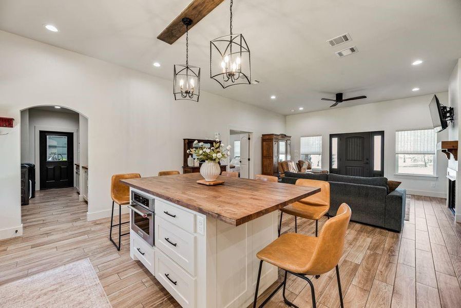Look at this Stunningly Beautiful Kitchen! Custom lighting throughout the cabinets, above, inset and under. Black Leathered Granite countertops, Quartz backsplash, butcher block island topper, pot filler, gas cook top and range and more!