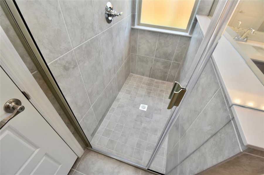 Bathroom with a stall shower and a sink