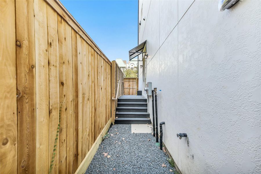 Clean and efficient, the side entry and utility area is designed for low-maintenance living with durable gravel walkways, wood privacy fencing, and direct access to the rear door. The layout maximizes space while concealing essential service connections with modern precision.