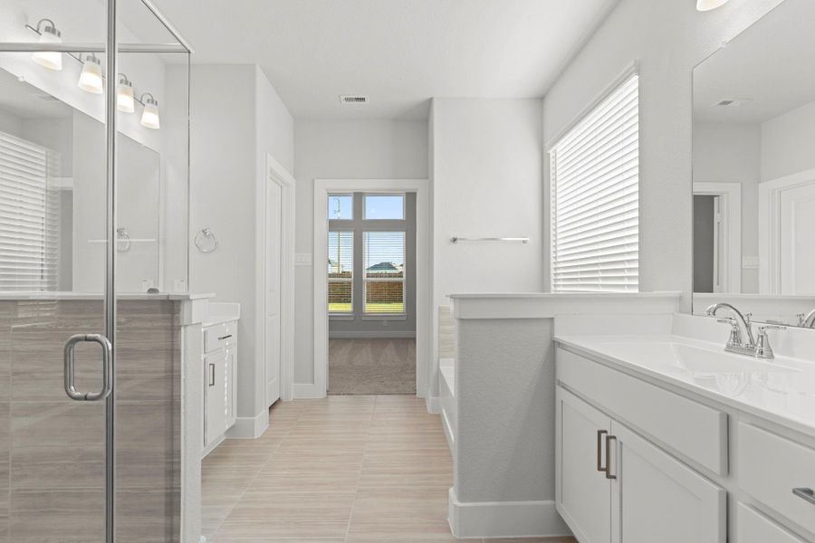 Every feature in this primary bath exudes sophistication—from the expansive dual vanities to the adjoining walk-in closet. Thoughtful design meets everyday functionality in this beautiful space.