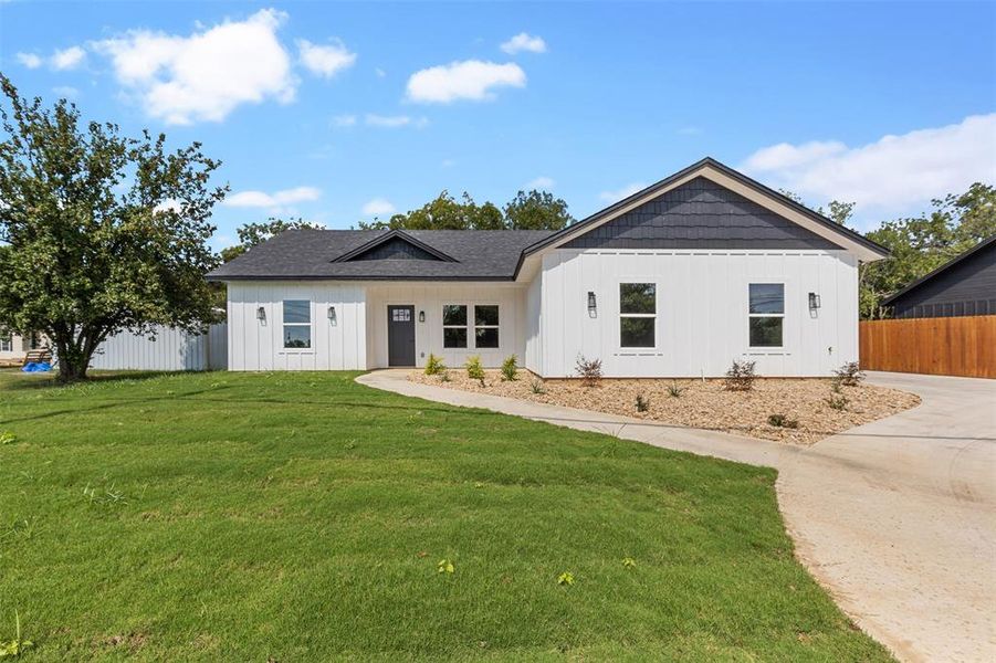 Modern inspired farmhouse featuring a front lawn