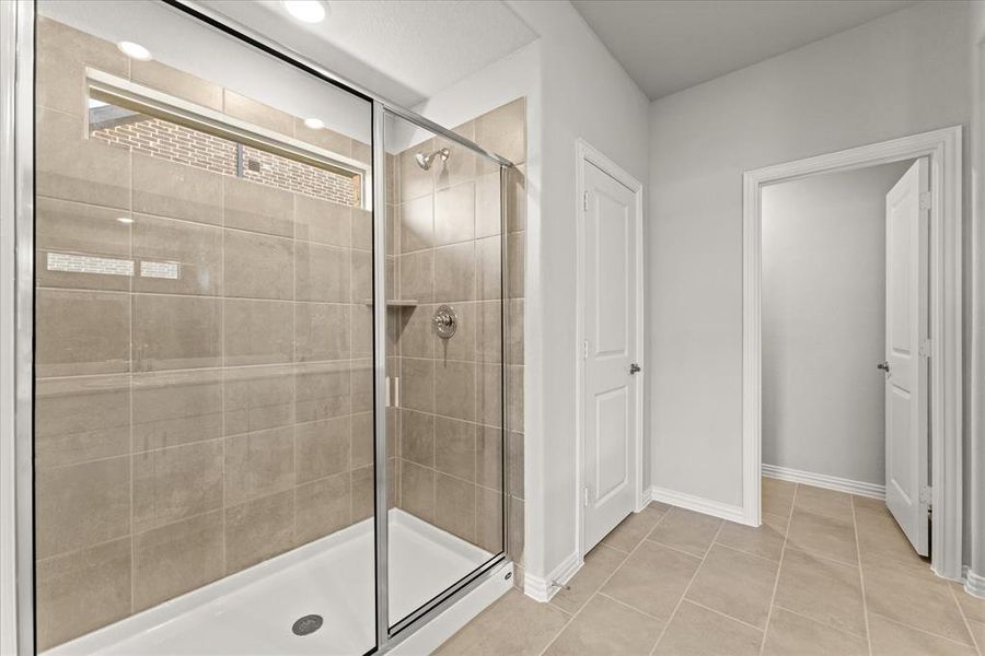 Bathroom with tile patterned flooring and a shower with door