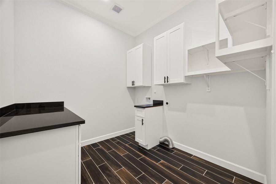 Functional laundry space with room with cabinetry and additional storage space