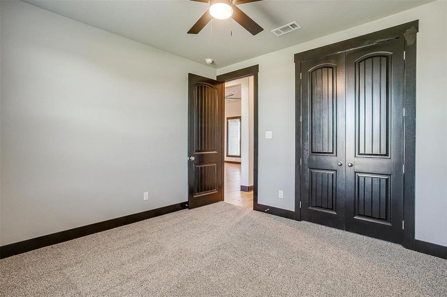 Unfurnished bedroom featuring light carpet, a closet, and ceiling fan