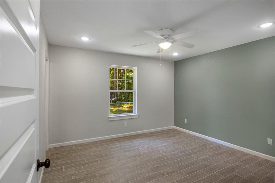 Empty room with recessed lighting, wood tiled floors, and a ceiling fan Empty room with recessed lighting, wood tiled floors, and a ceiling fan