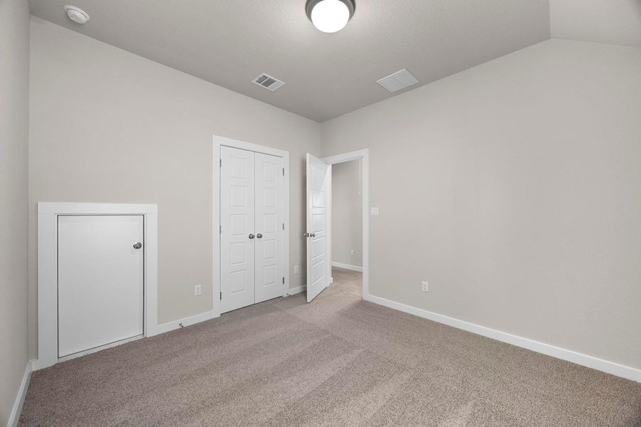 A well-lit bedroom features plush carpeting and convenient closet access. A well-lit bedroom features plush carpeting and convenient closet access.