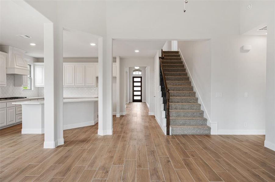 Foyer featuring light wood finished floors, recessed lighting, and stairs