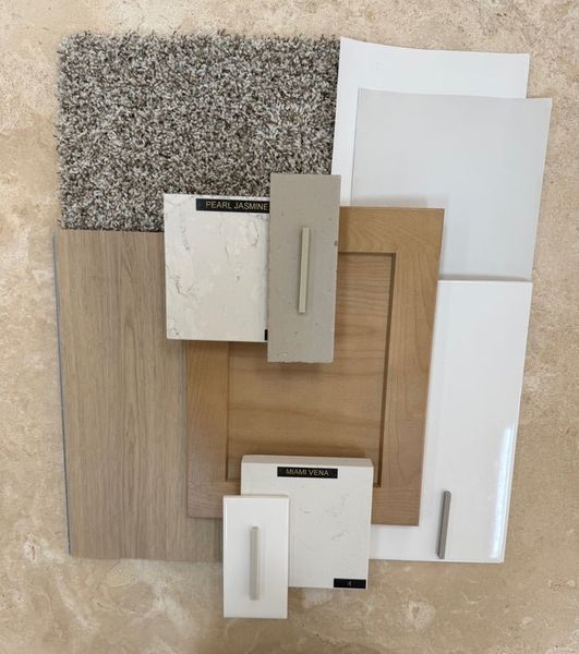 Interior design material board with wood flooring, gray carpet, white cabinets, and Pearl Jasmine and Miami Vena countertop samples. Interior design material board with wood flooring, gray carpet, white cabinets, and Pearl Jasmine and Miami Vena countertop samples.