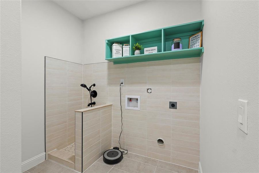 Laundry area with hookup for a washing machine, hookup for an electric dryer, pet washing area, a textured wall, and gas dryer hookup