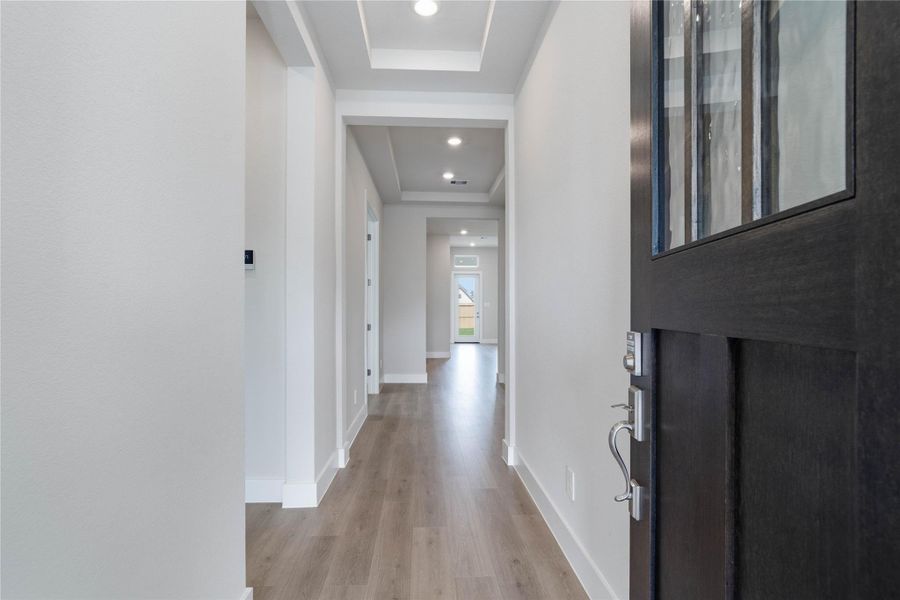 Welcome inside to a bright and inviting entryway that sets the tone for this modern home. Crisp neutral toned walls and abundant natural light create an open and spacious feel throughout the hallway. The laminate flooring extends seamlessly through the area, offering both aesthetic appeal and durability.