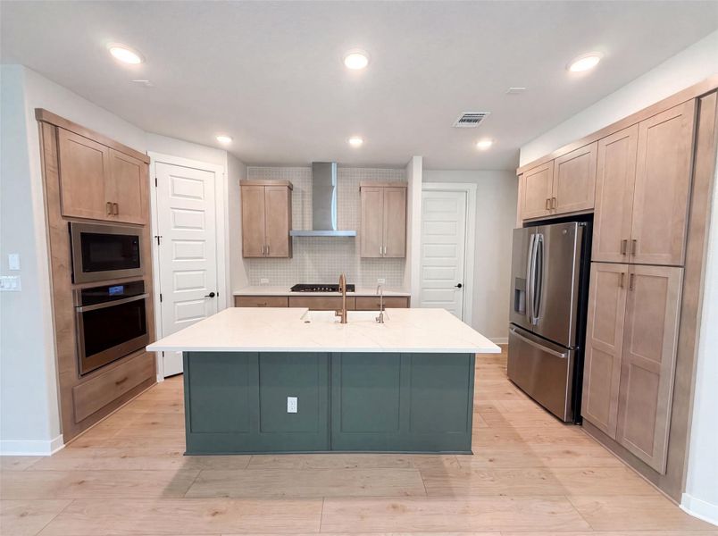 Culinary excellence awaits in this well-appointed kitchen, showcasing a spacious island, built-in appliances, and warm wood cabinetry. Culinary excellence awaits in this well-appointed kitchen, showcasing a spacious island, built-in appliances, and warm wood cabinetry.