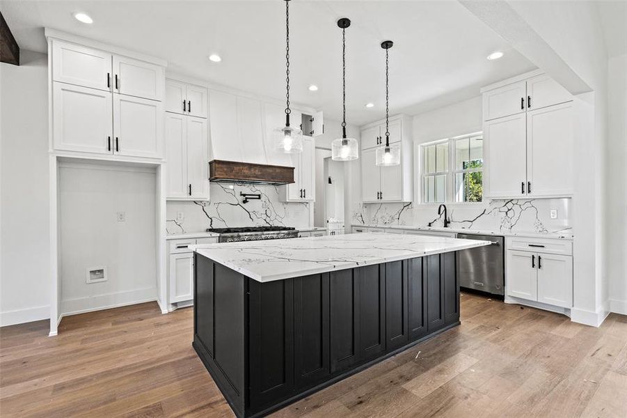 Kitchen with dark cabinets, white cabinetry, light stone countertops, and recessed lighting Kitchen with dark cabinets, white cabinetry, light stone countertops, and recessed lighting