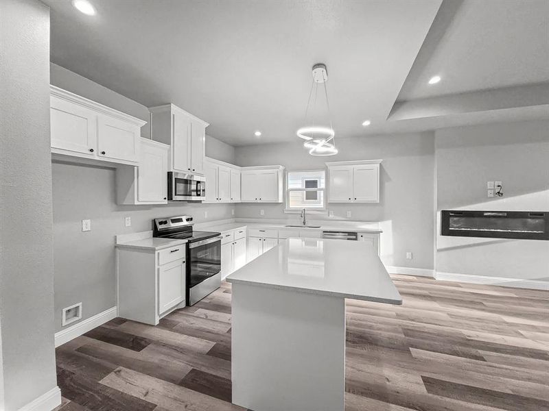 Kitchen with stainless steel appliances, baseboards, a sink, wood finished floors, and recessed lighting Kitchen with stainless steel appliances, baseboards, a sink, wood finished floors, and recessed lighting