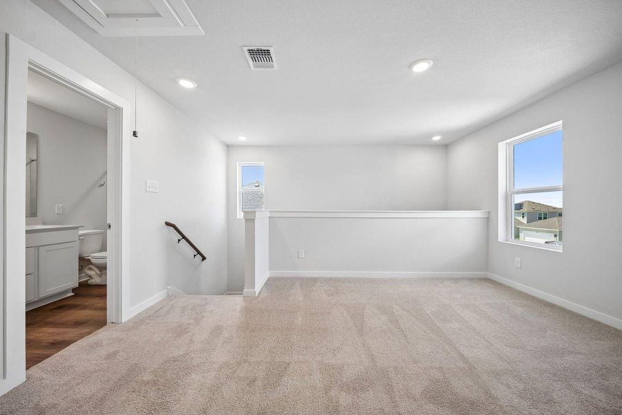 A versatile open loft space featuring carpeted flooring and abundant overhead lighting. A versatile open loft space featuring carpeted flooring and abundant overhead lighting.