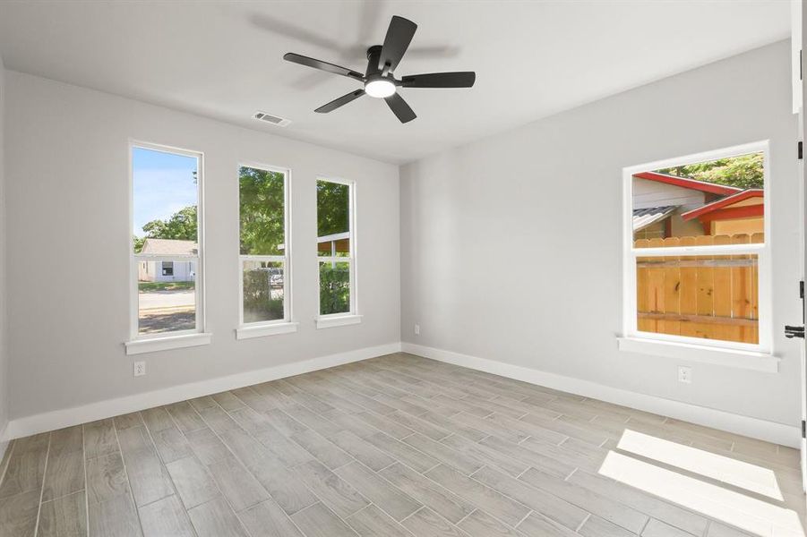 Empty room featuring baseboards, a ceiling fan, and light wood finished floors