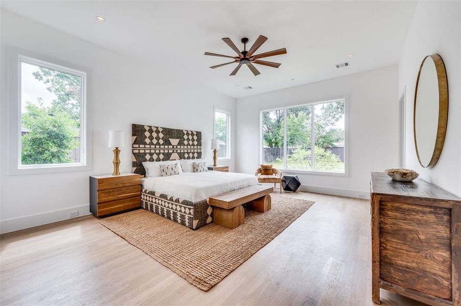 Bedroom featuring light hardwood / wood-style floors, multiple windows, and ceiling fan