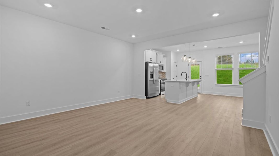 Spacious family room with rich hardwood flooring and elegant trim work in a reputable DRB Homes build Spacious family room with rich hardwood flooring and elegant trim work in a reputable DRB Homes build