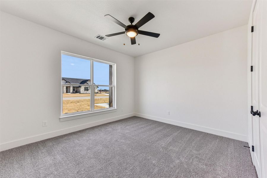 Empty room featuring light colored carpet and ceiling fan