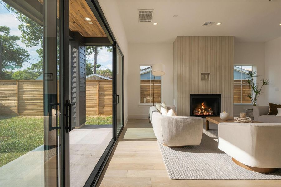 Expansive 16-foot Pella sliding doors blur the line between indoors and out, filling the living space with natural light and opening directly to the covered patio and oversized backyard.