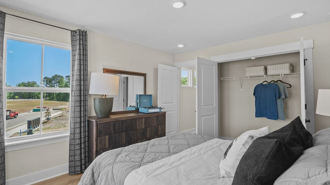 Spacious second-floor bedroom in the Summit home plan with natural light and style.
