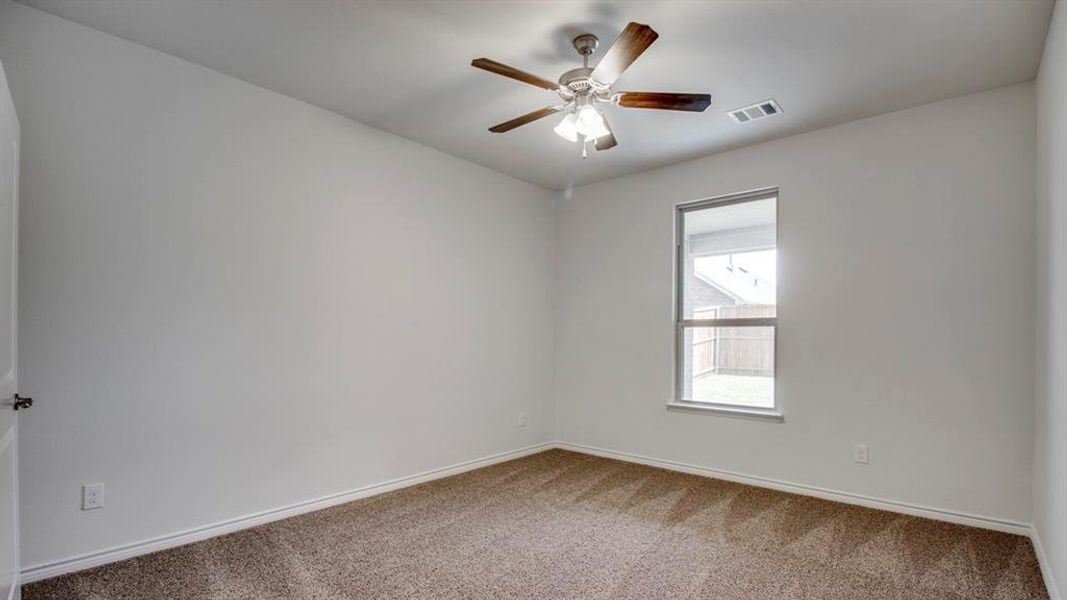 Carpeted spare room with baseboards and a ceiling fan Carpeted spare room with baseboards and a ceiling fan
