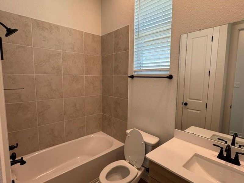A well-appointed bathroom features a bathtub, tiled shower, and sleek vanity with modern fixtures.
