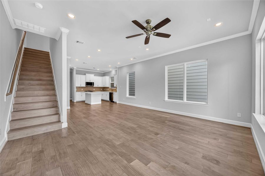 Where Everyone Ends Up – Wood floors, a ceiling fan, and a clear sightline to the kitchen make this the room life naturally gathers in.