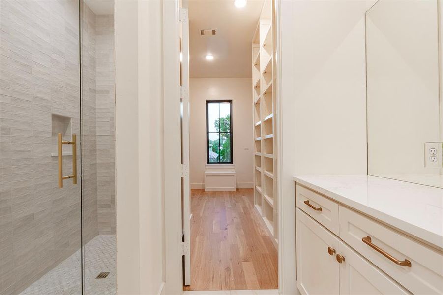 Shower with view to one of the closets in primary