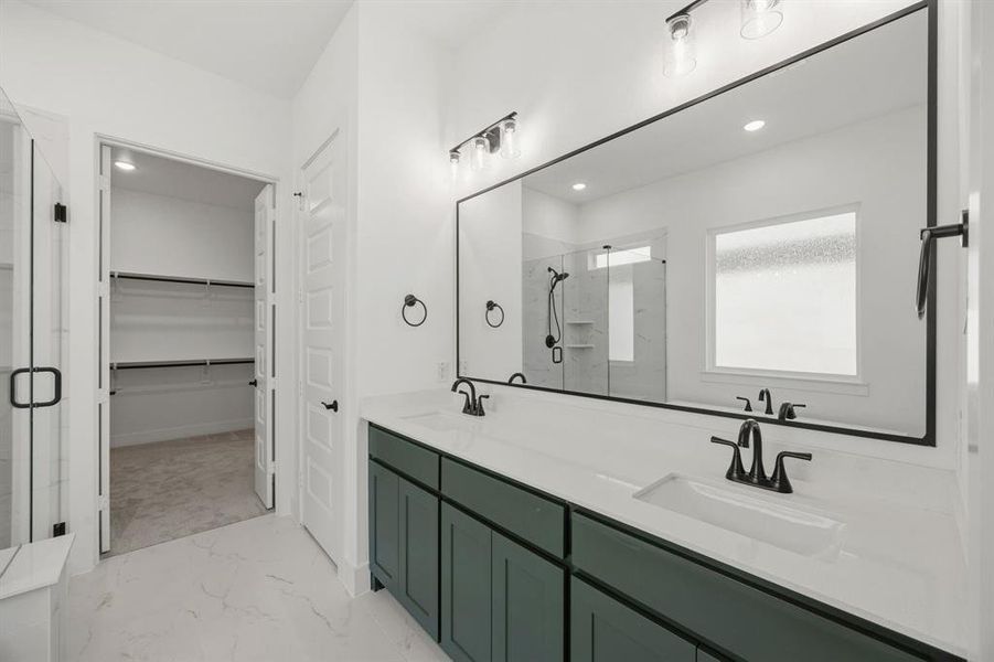 Bathroom with double vanity, a spacious closet, a marble finish shower, and light marble finish floors